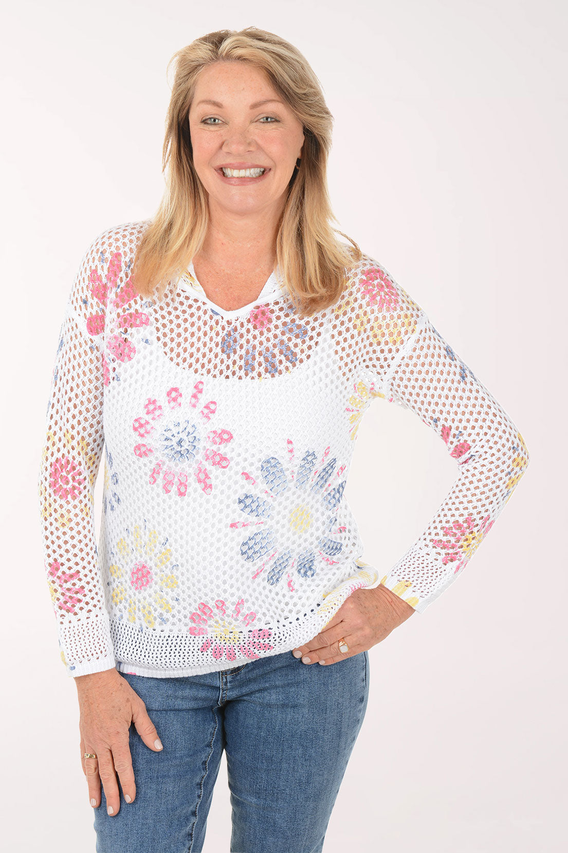 Woman wearing a white floral-patterned sweater on a white background
