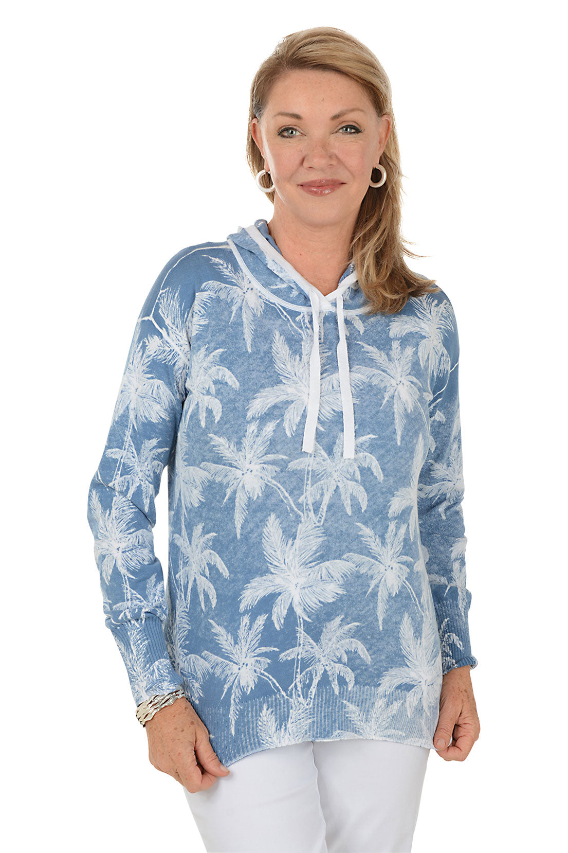 Woman wearing a blue hoodie with palm tree pattern on a white background