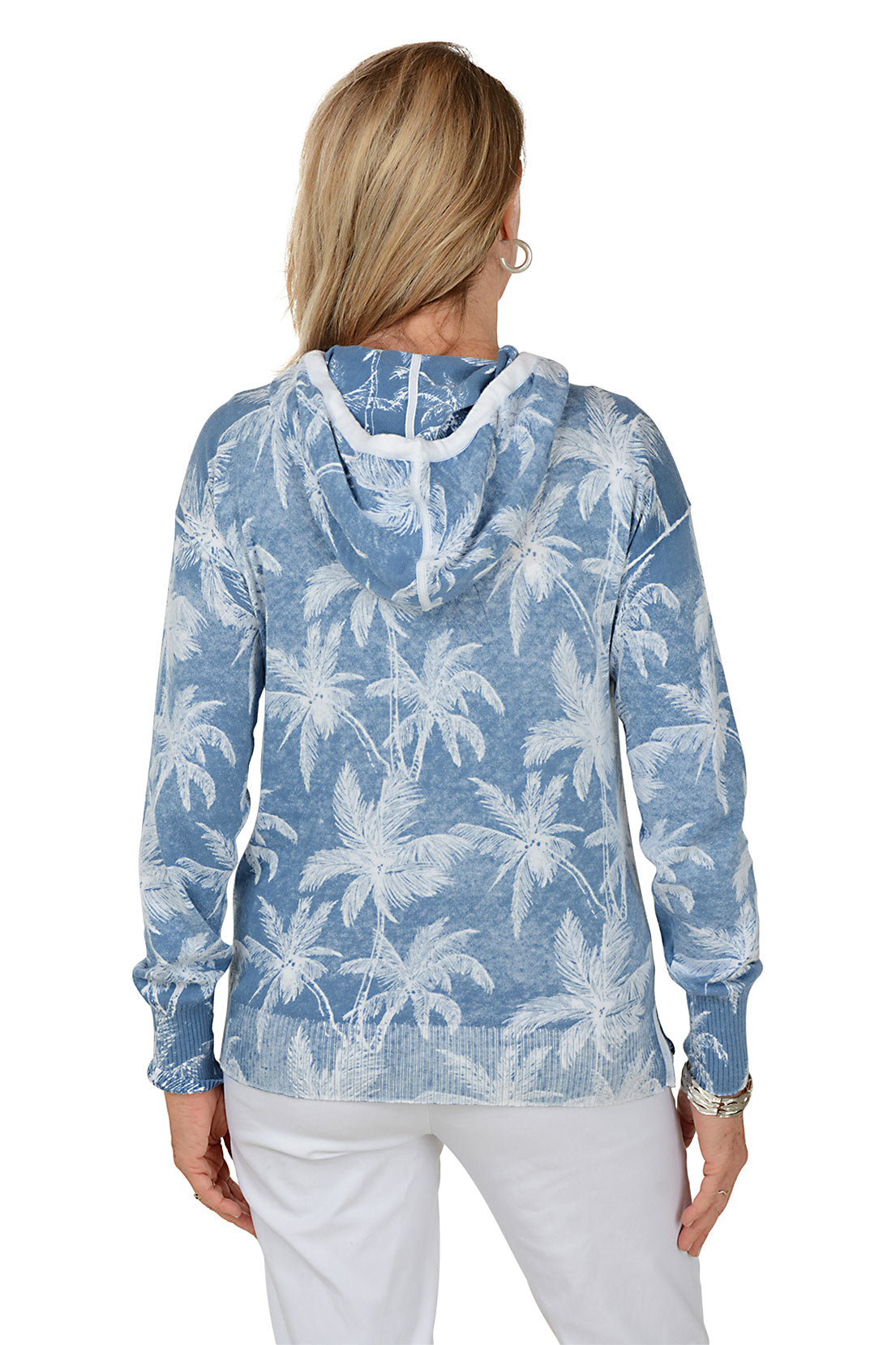 Woman wearing a blue hoodie with palm tree pattern on a white background