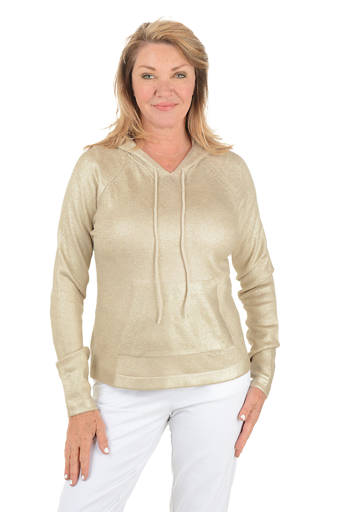 Woman wearing a gold hoodie and white pants on a white background.