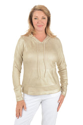 Woman wearing a gold hoodie and white pants on a white background.