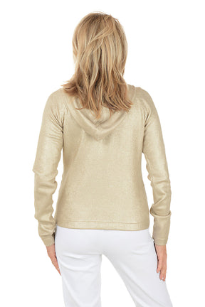 Woman wearing a gold hoodie and white pants on a white background. Back shot.