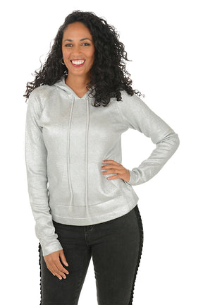 Woman wearing a silver hoodie and white pants on a white background.