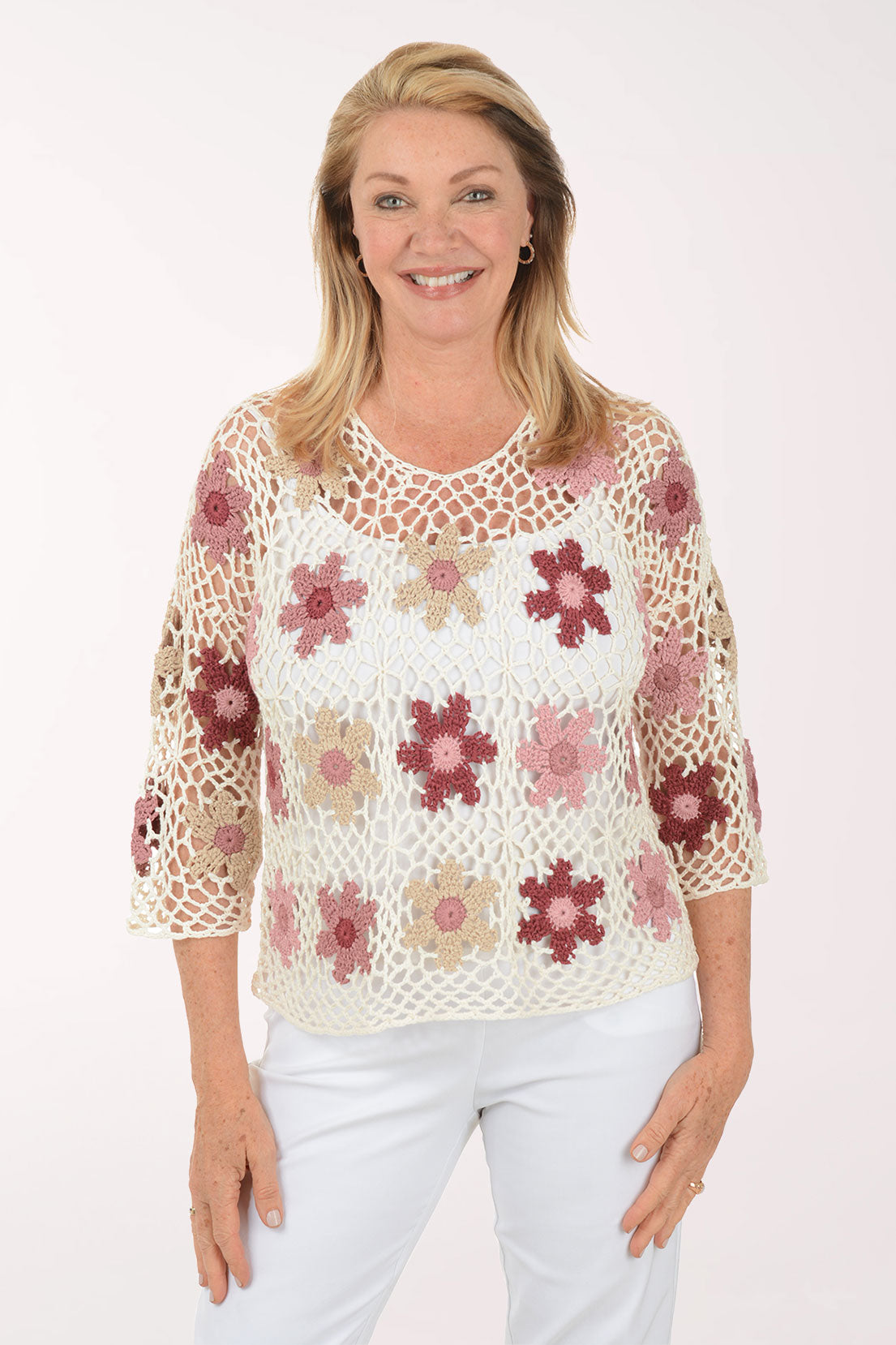 Woman wearing a floral crochet top on a white background