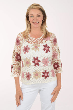 Woman wearing a floral crochet top on a white background
