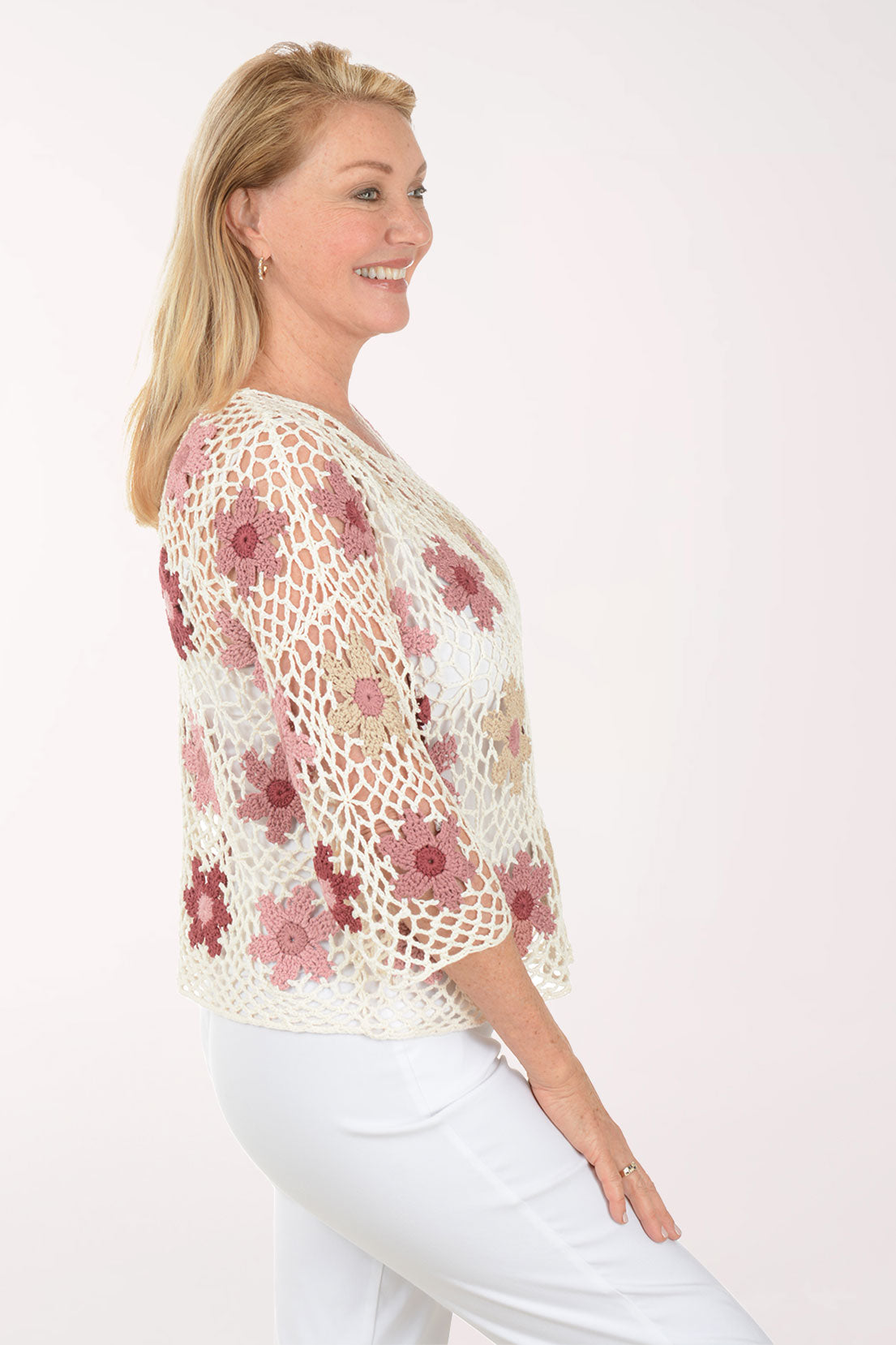 Woman wearing a floral crochet top on a white background