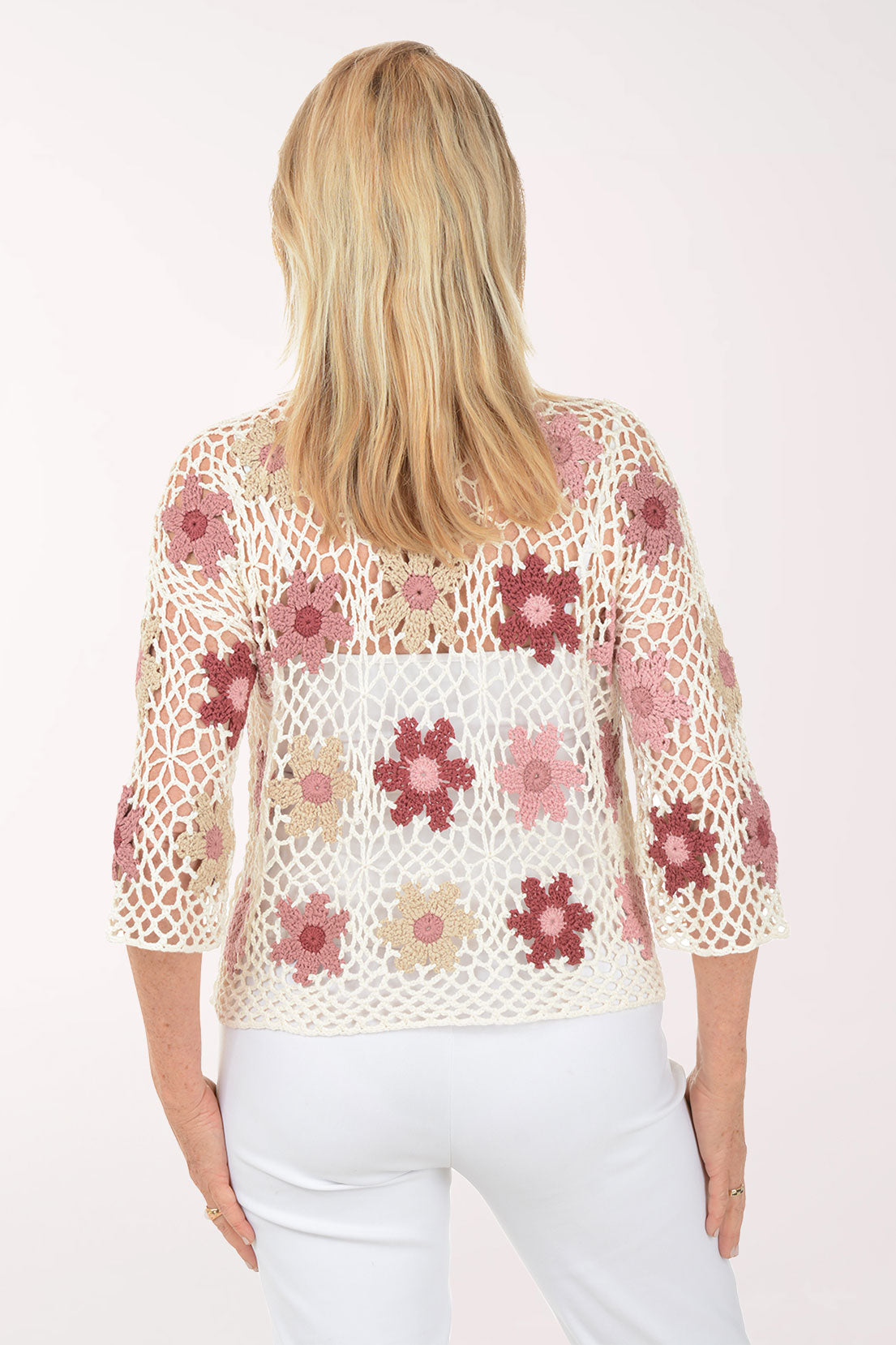 Woman wearing a floral crochet top on a white background