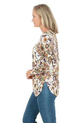 Woman wearing a floral long-sleeve top on a white background. Side shot.
