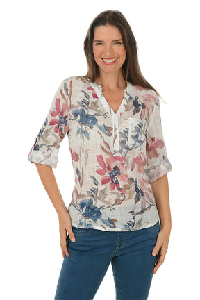 Woman wearing a floral blouse with blue jeans on a white background