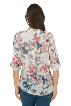 Woman wearing a floral blouse with blue jeans on a white background