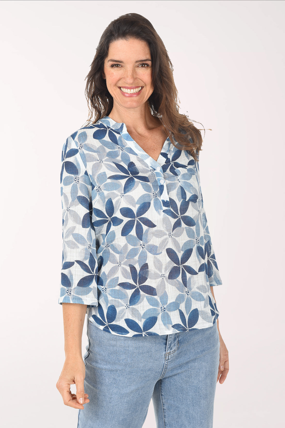 Woman wearing a blue floral patterned blouse against a white background