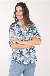 Woman wearing a blue floral patterned blouse against a white background