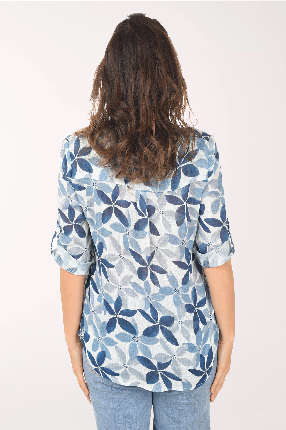 Woman wearing a blue floral patterned blouse against a white background