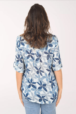Woman wearing a blue floral patterned blouse against a white background