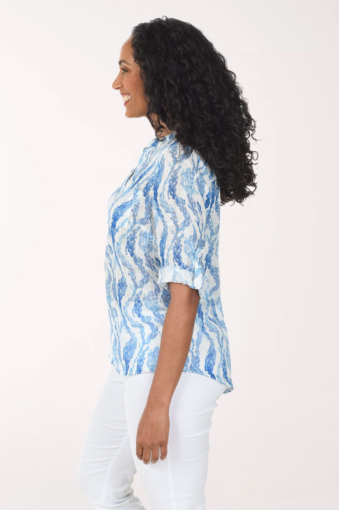 Woman wearing a blue patterned blouse against a white background