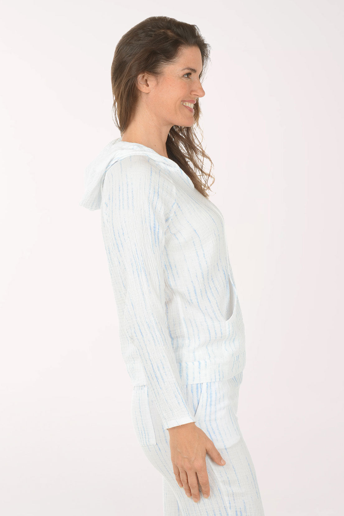 Woman wearing a light blue striped shirt and pants on a white background