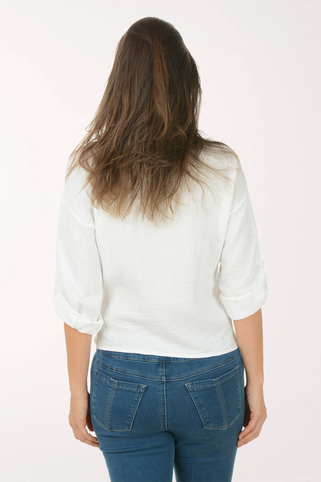 Woman wearing a white blouse and blue jeans on a white background