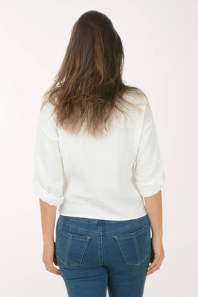 Woman wearing a white blouse and blue jeans on a white background