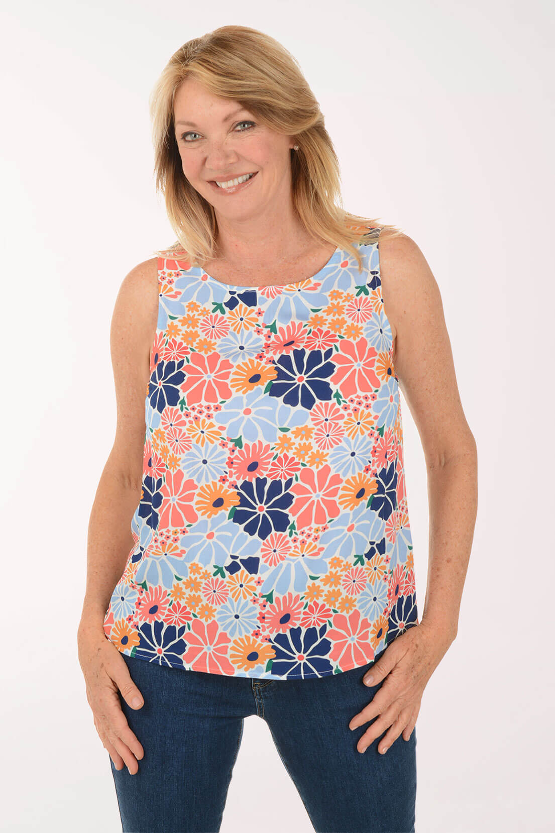 Woman wearing a colorful floral sleeveless top on a white background