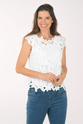 Woman wearing a white lace top and blue jeans on a white background