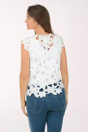 Woman wearing a white lace top and blue jeans on a white background