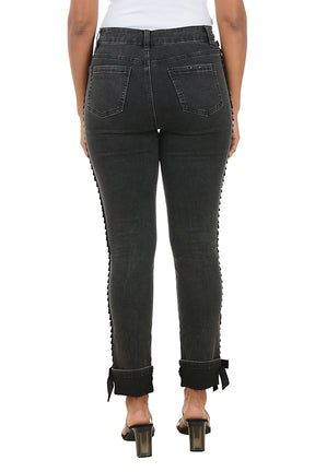 Person wearing black jeans with ruffled edges on a white background. Back shot.