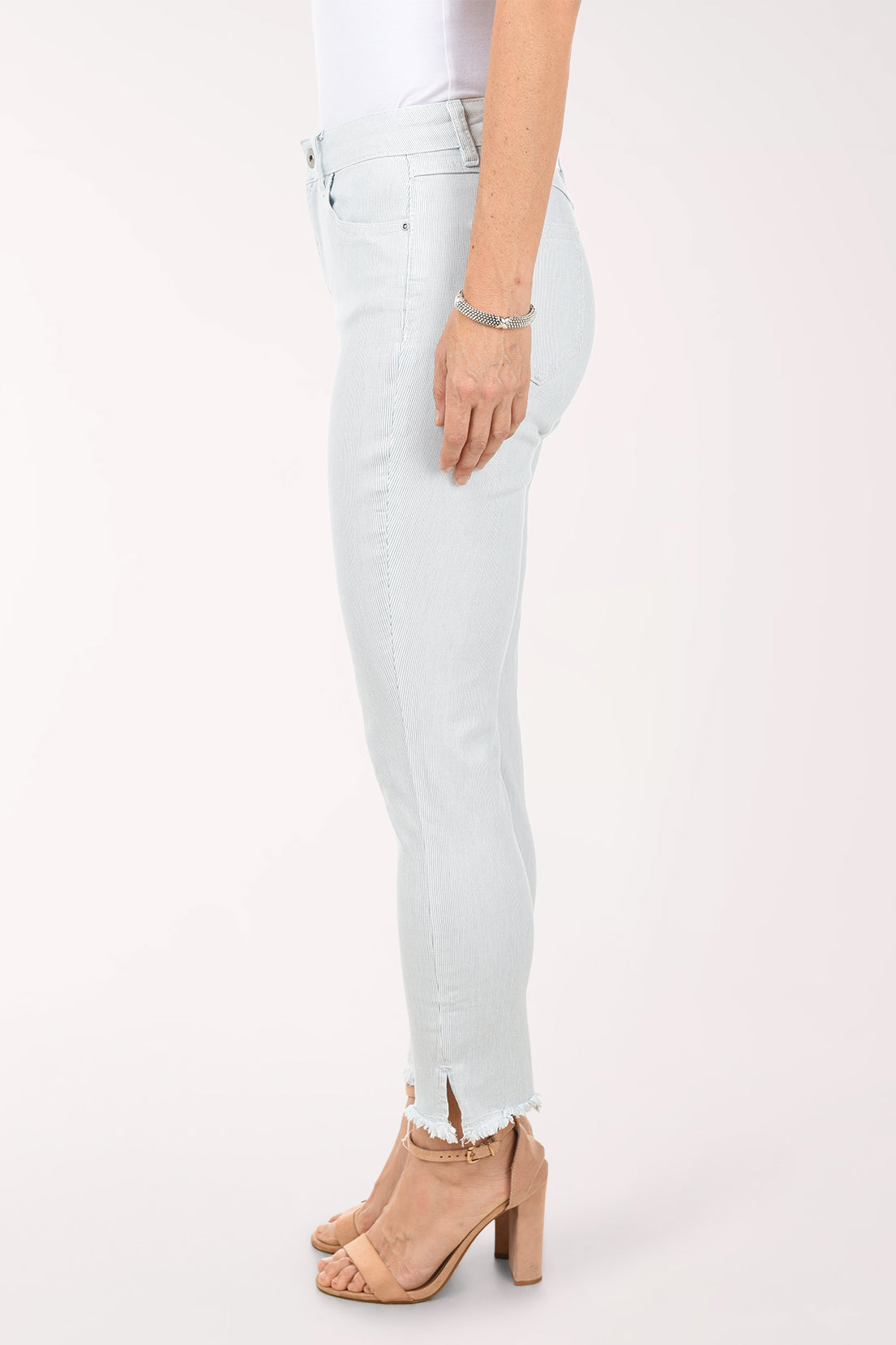 Person wearing light blue jeans with a white background