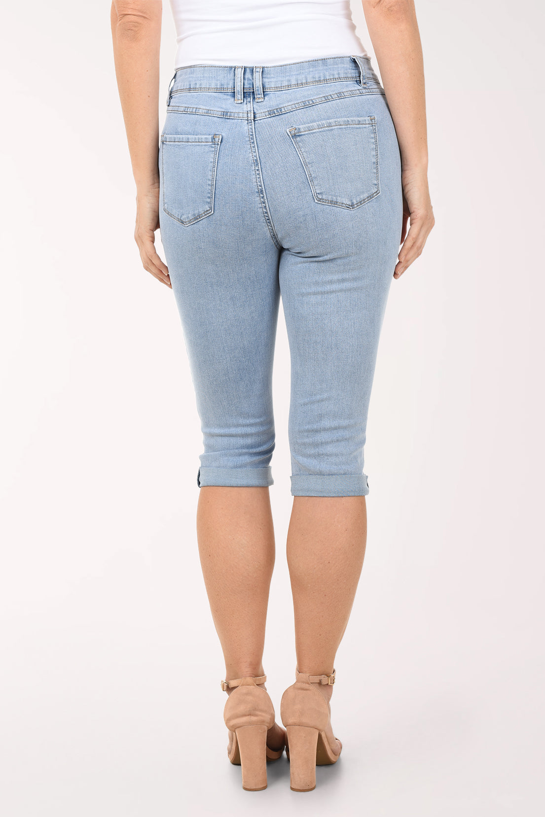 Light blue denim capri jeans worn by a person on a white background