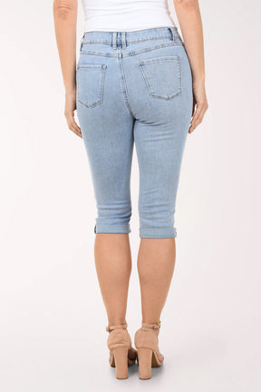 Light blue denim capri jeans worn by a person on a white background
