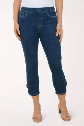 Person wearing blue jeans and beige sandals on a white background