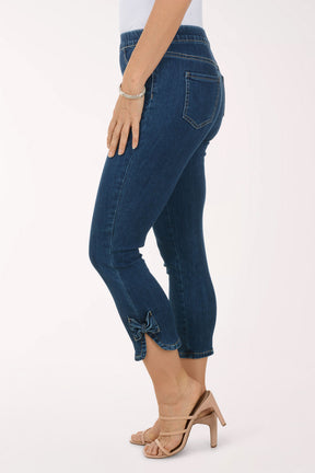 Person wearing blue jeans and beige sandals on a white background