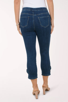 Person wearing blue jeans and beige sandals on a white background