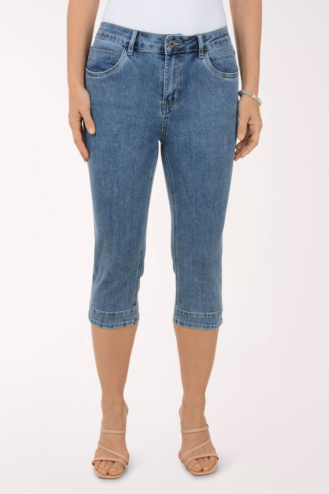 Woman wearing a floral blouse and blue jeans on a white background