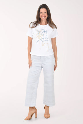 Woman wearing a white t-shirt with a graphic design and light blue jeans on a white background