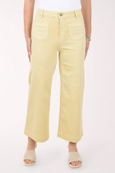 Person wearing light yellow pants on a white background