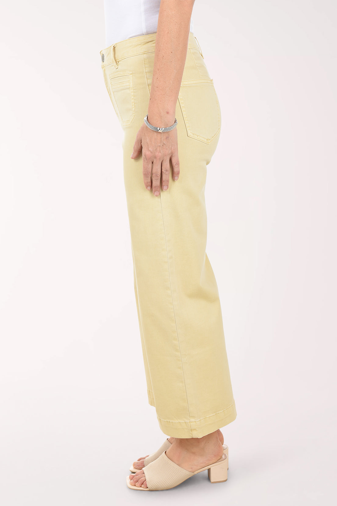 Person wearing light yellow pants on a white background