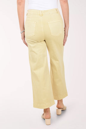 Person wearing light yellow pants on a white background