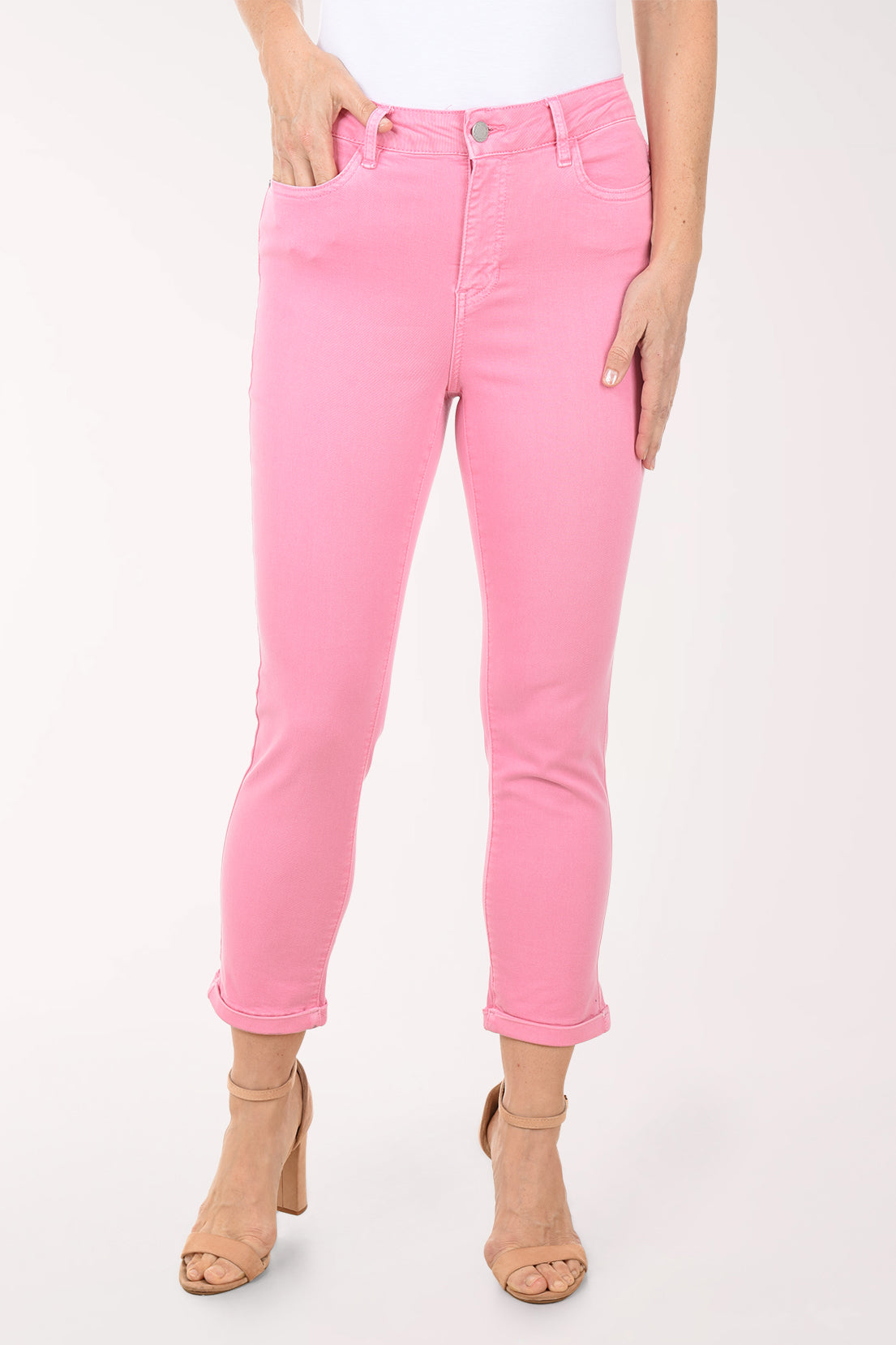 Woman wearing a floral blouse and pink pants on a white background