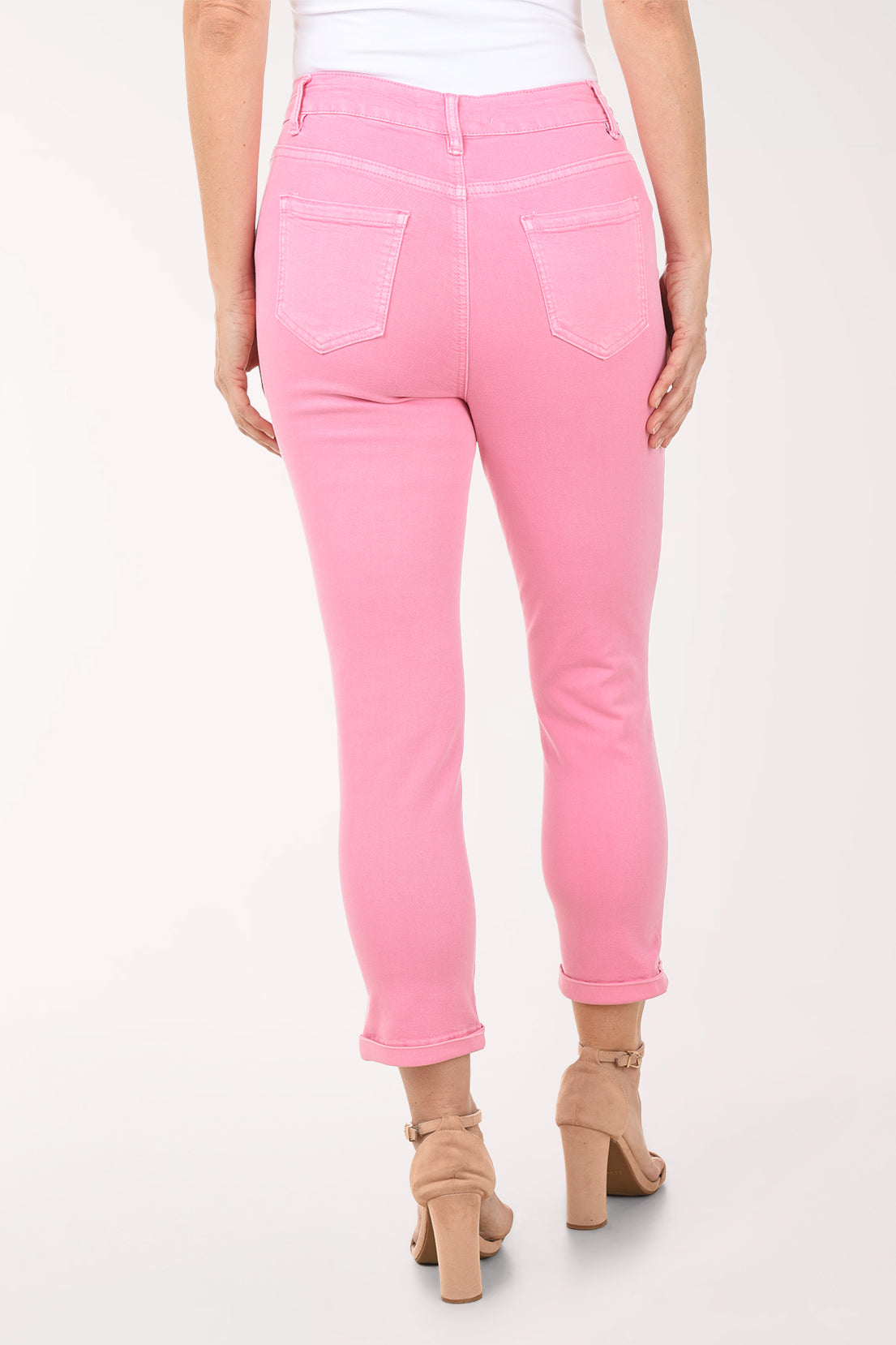 Woman wearing a floral blouse and pink pants on a white background