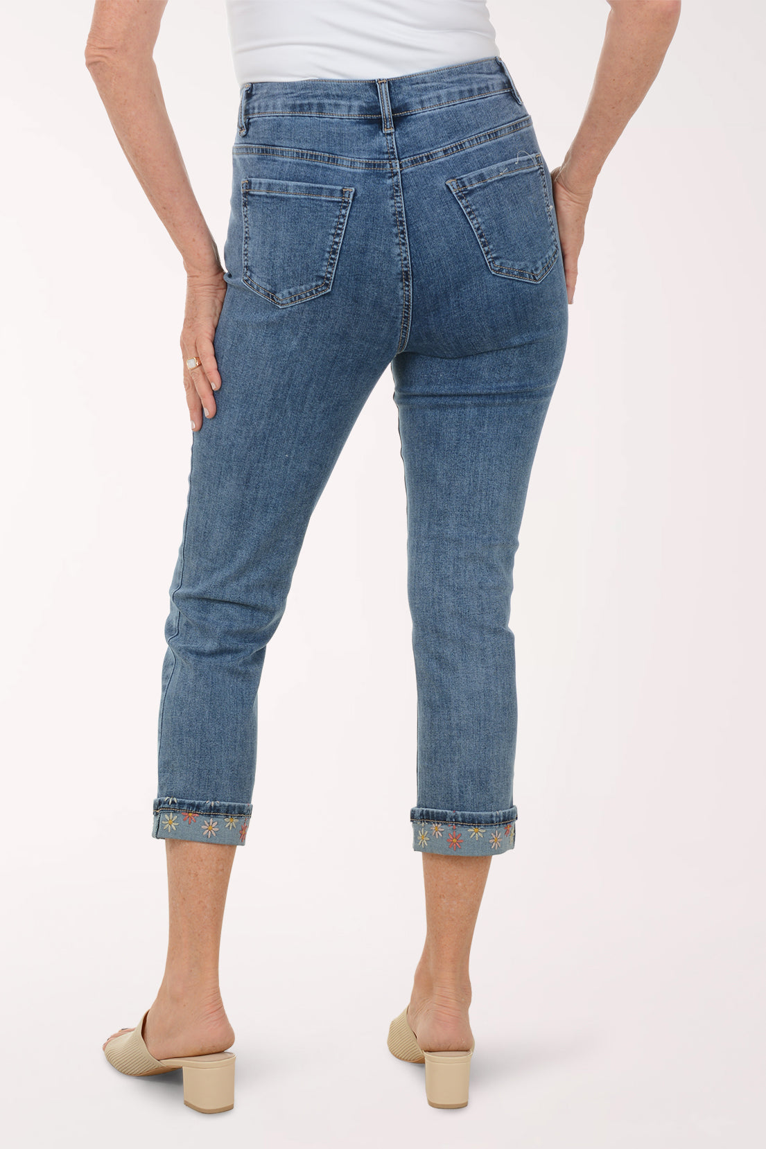 Person wearing blue jeans on a white background