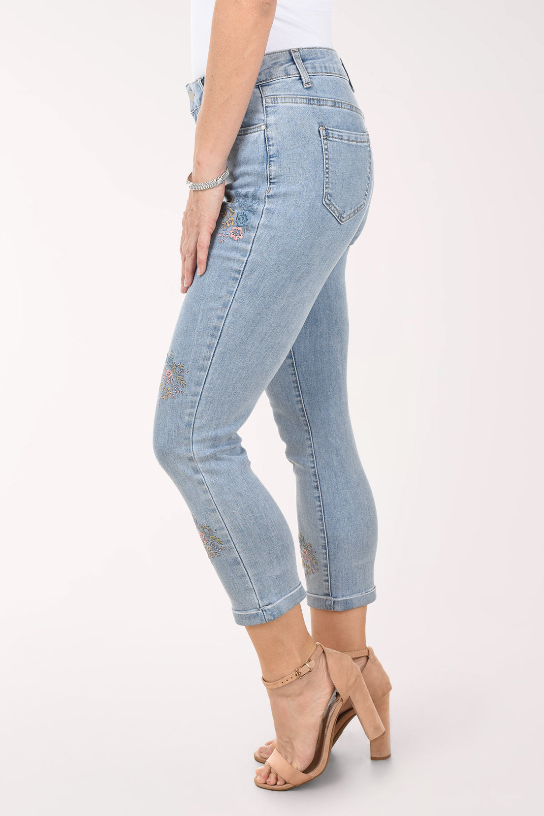Light blue jeans with floral embroidery on a white background