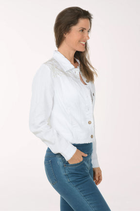 Woman wearing a white denim jacket with gold buttons on a white background