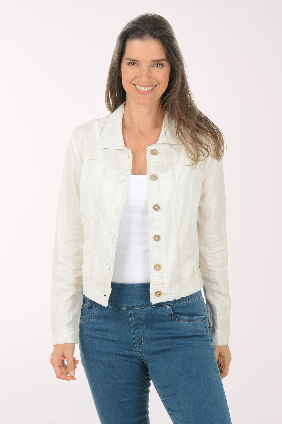 Woman wearing a white denim jacket and blue jeans on a white background