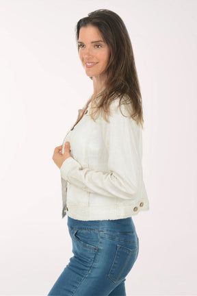 Woman wearing a white denim jacket and blue jeans on a white background