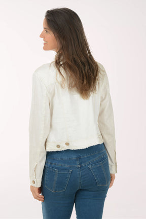 Woman wearing a white denim jacket and blue jeans on a white background
