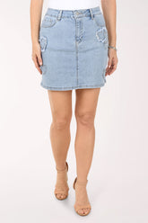 Light blue denim skirt worn by a person on a white background