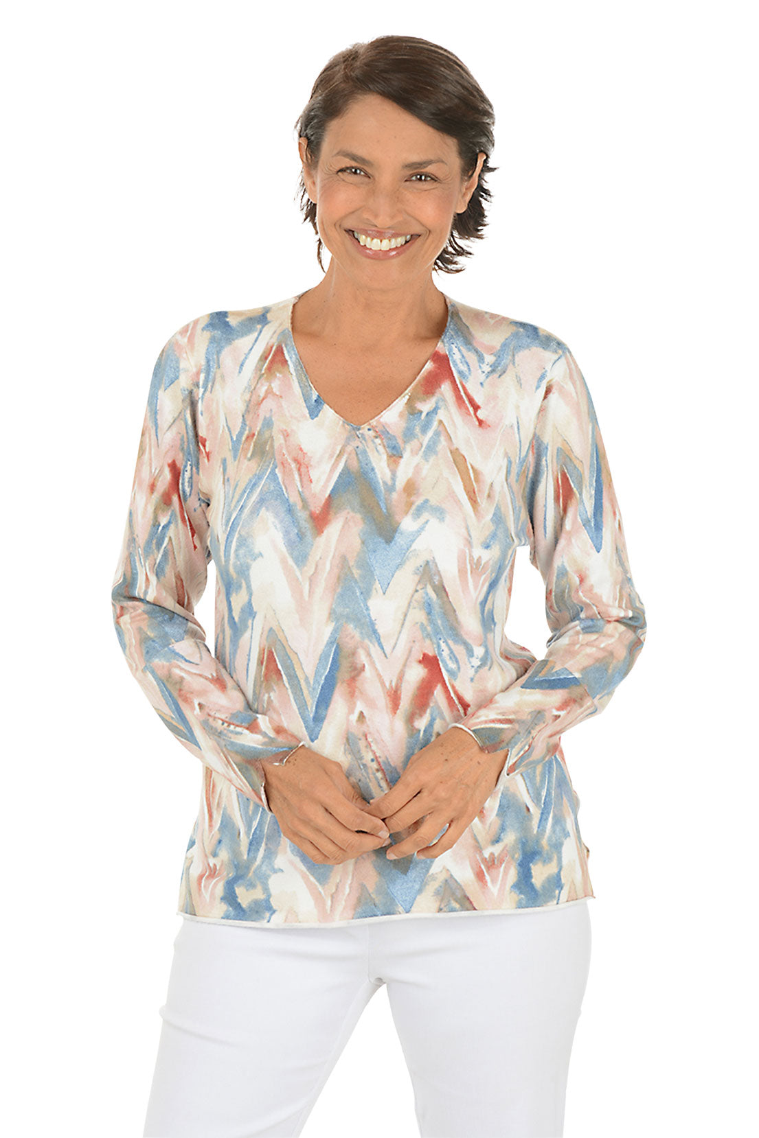 Woman wearing a colorful zigzag patterned sweater on a white background.