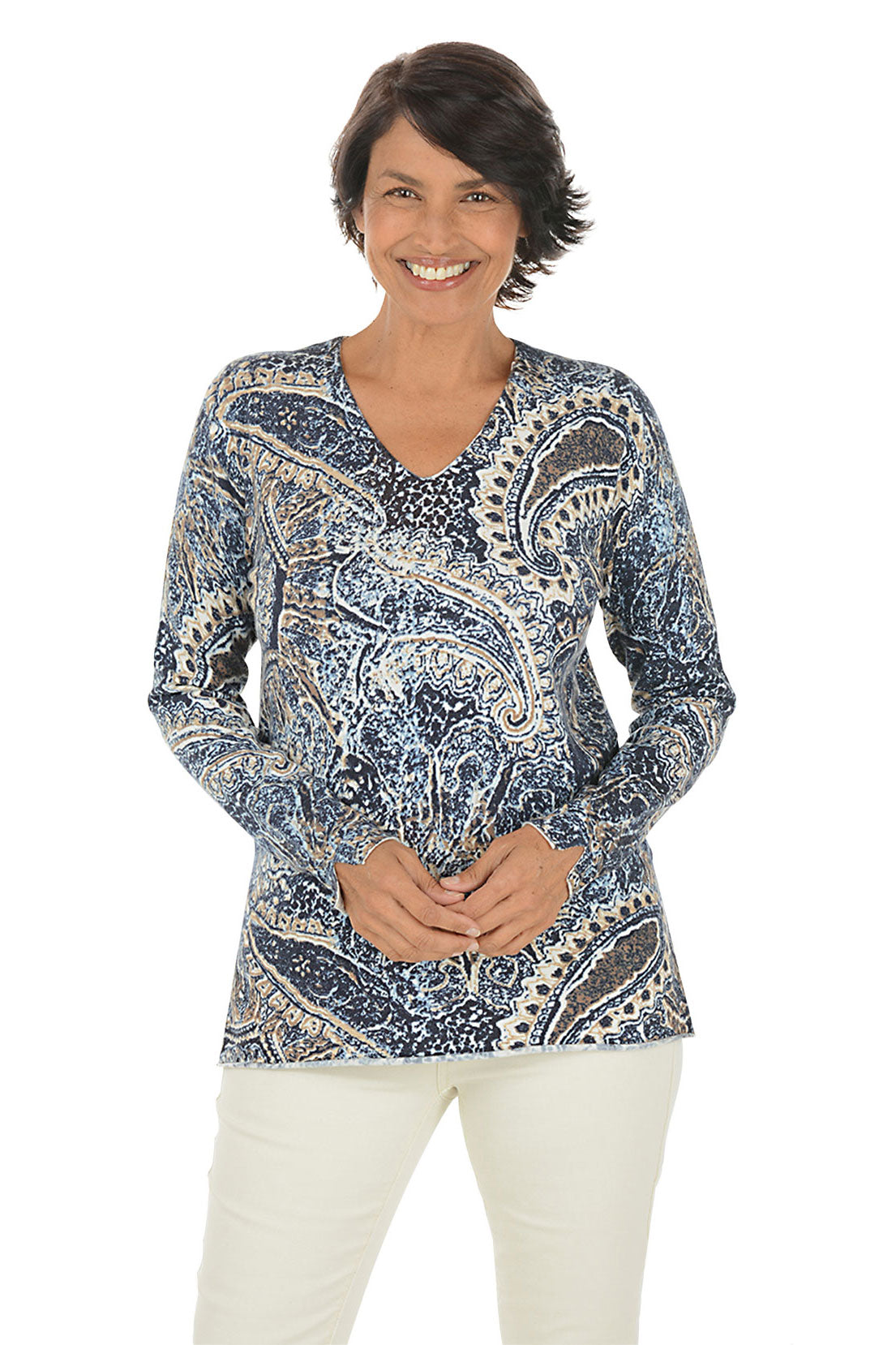 Woman wearing a blue paisley patterned sweater on a white background.