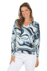 Woman wearing a blue and white marbled long-sleeve sweater on a white background.