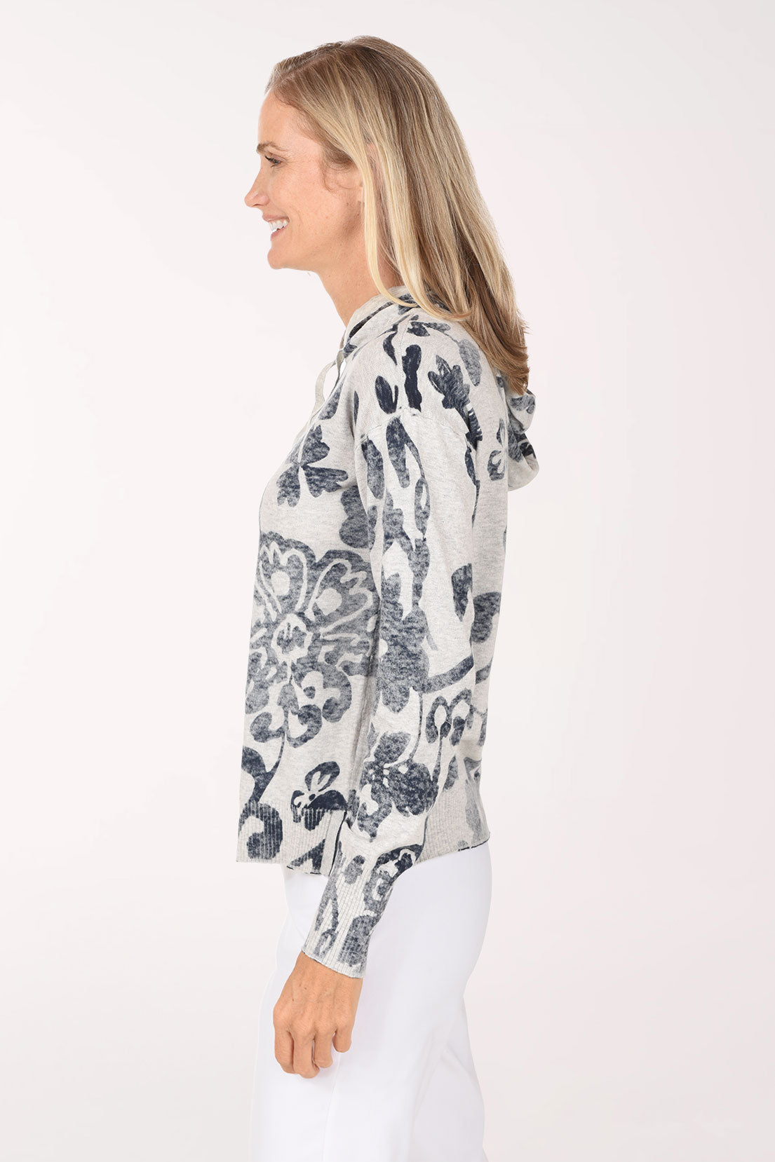 A side view of the floral print hoodie showing the dolman sleeves and ribbed cuffs.